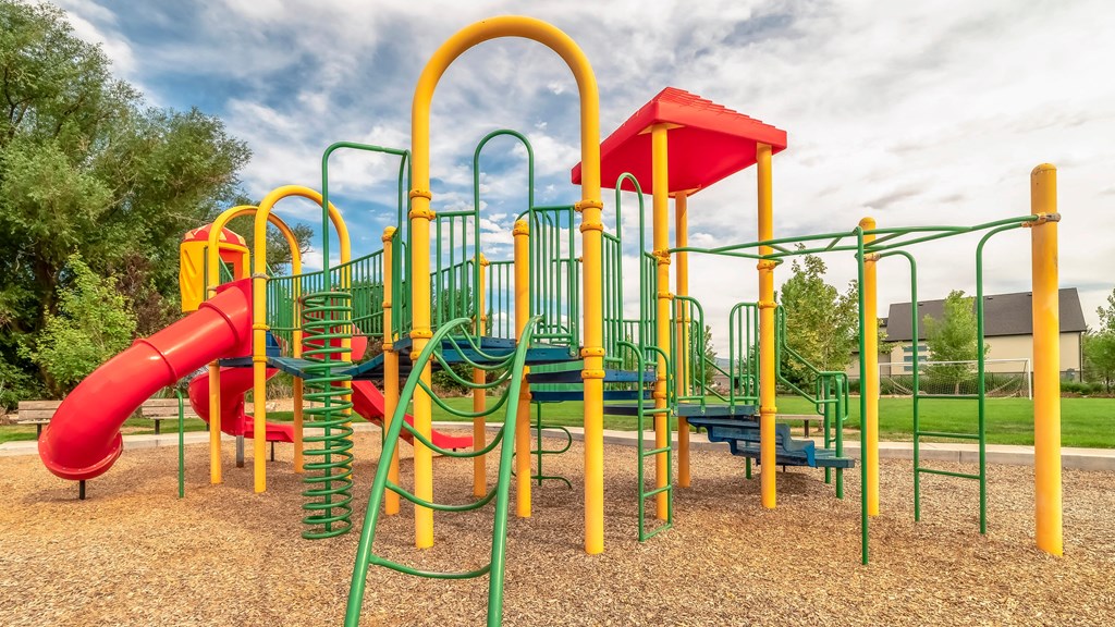 a playground at a park with a red slide