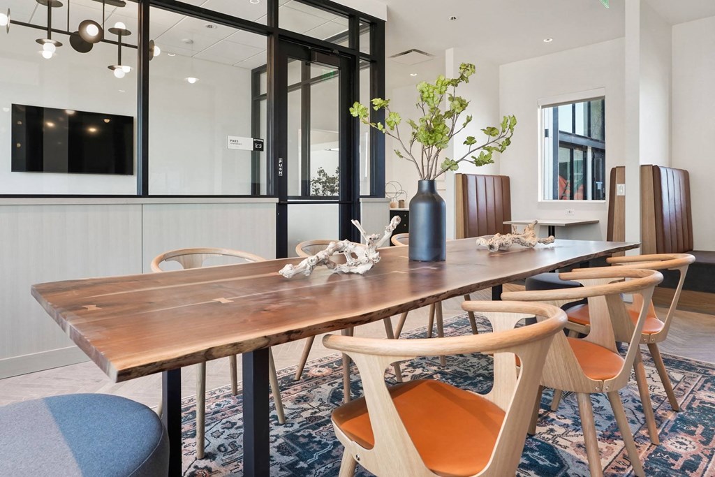 a dining room with a long wooden table and orange chairs