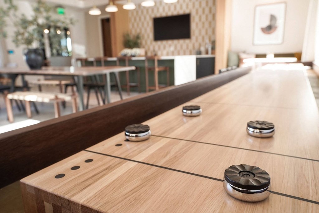 Apartments in Castle Rock, CO for Rent - Alana - Clubhouse with a Shuffle Board, Kitchen Area, and Mounted Television