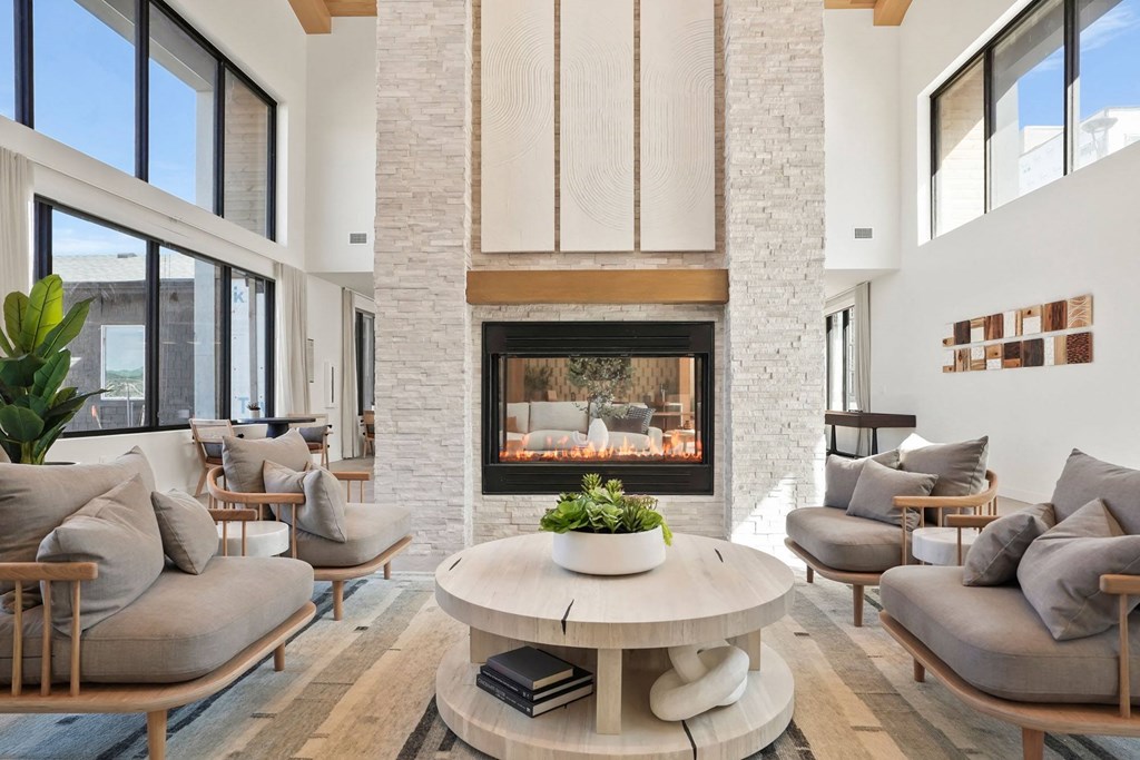 a living room with couches and a coffee table in front of a fireplace