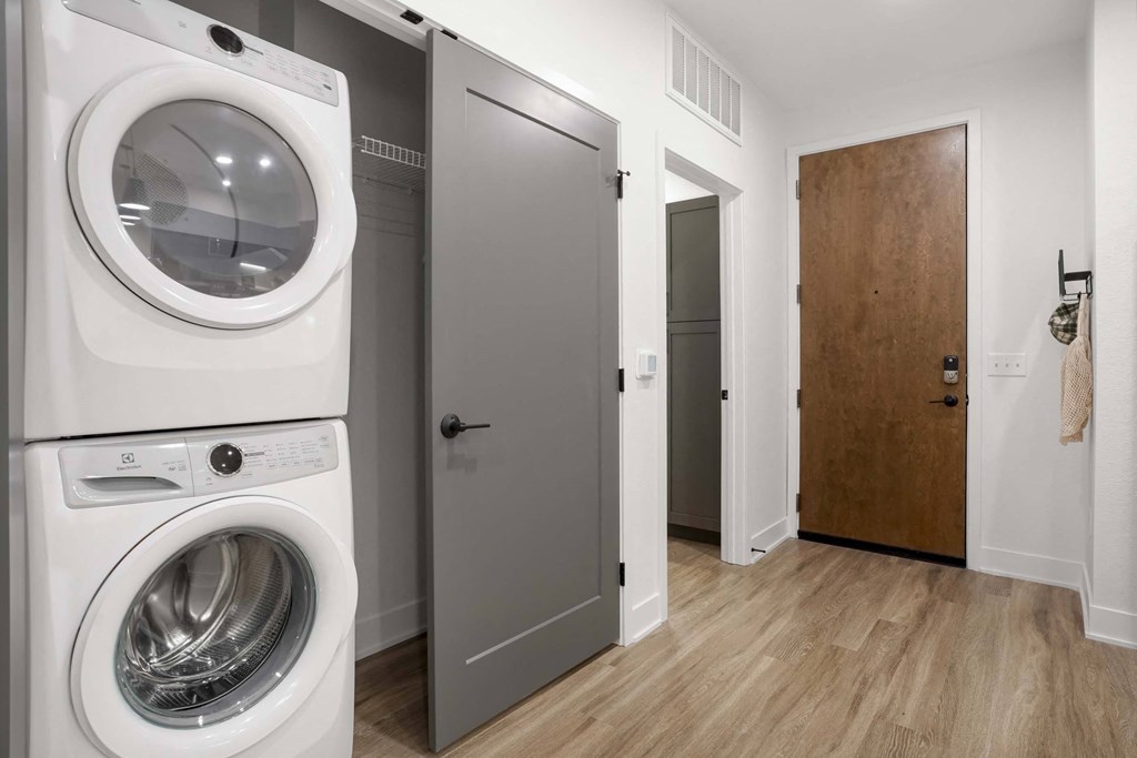 a white washer and dryer in a room with a door