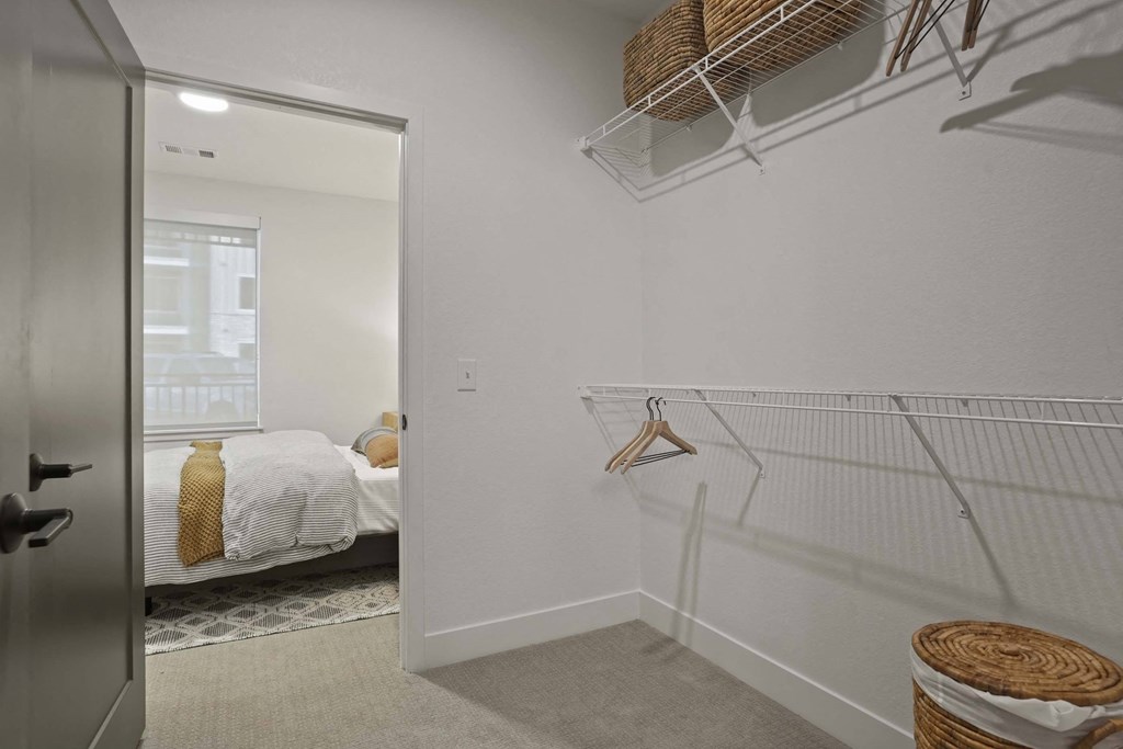 the closet in a bedroom with a bed and a mirror