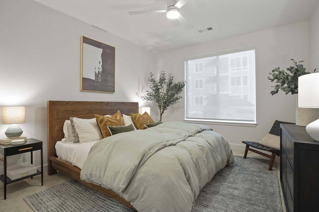 Two-Bedroom Apartments in Castle Rock, CO - Alana - Bedroom with Plush Carpet Flooring, Ceiling Fan, and Large Window