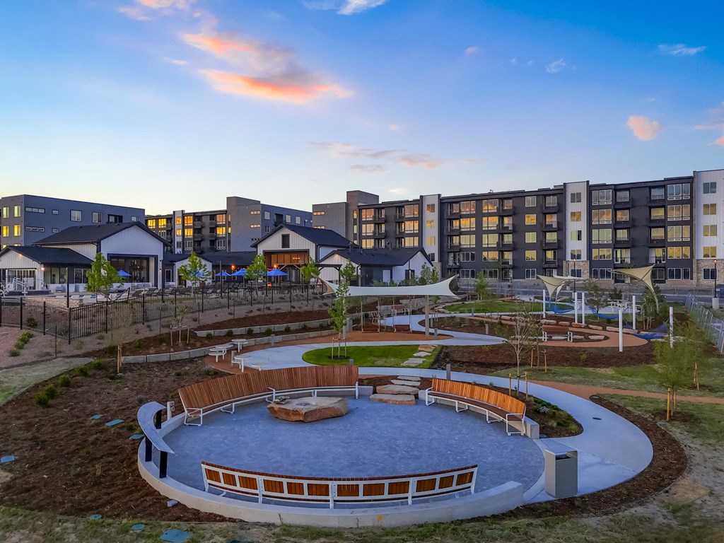 a view of a park with a playground and buildings