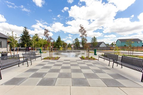 A checkerboard patterned walkway with benches on either side.