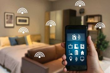 A hand holding a smartphone with Wi-Fi symbols floating around it.