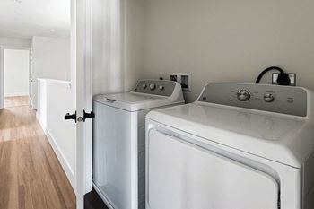 A white washing machine and dryer in a laundry room.