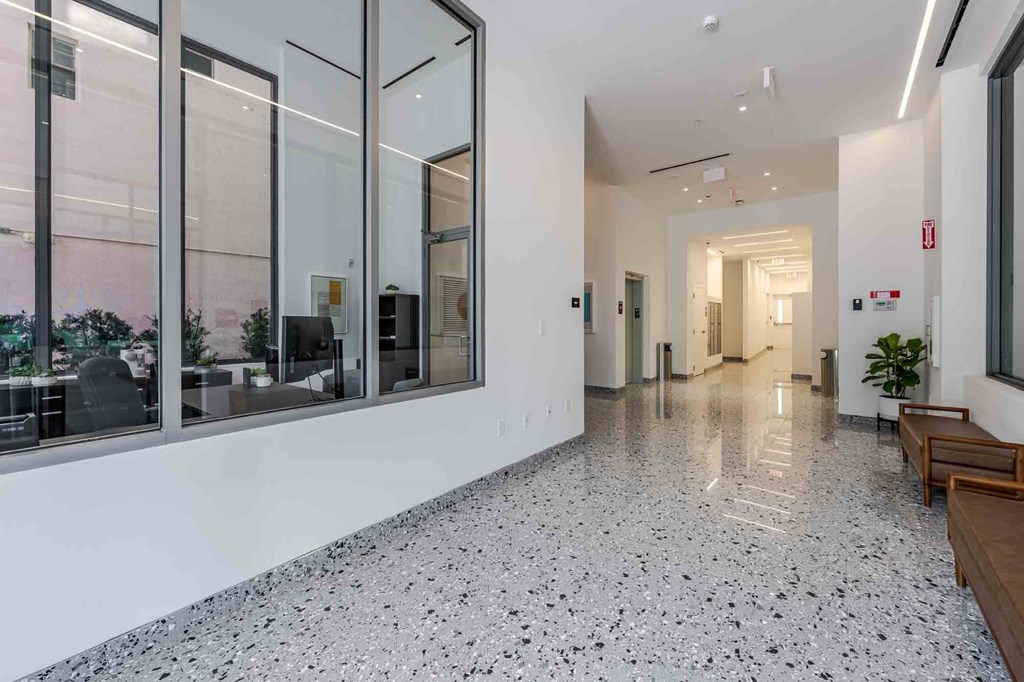 A long hallway with a tiled floor and glass walls on one side.