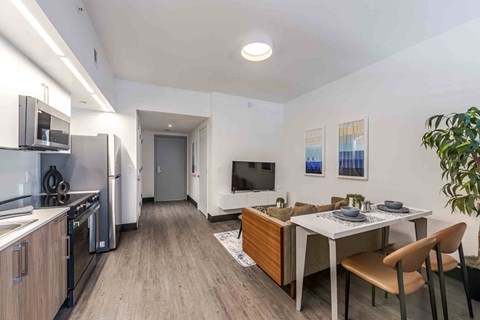 A modern kitchen with a dining table set for two.