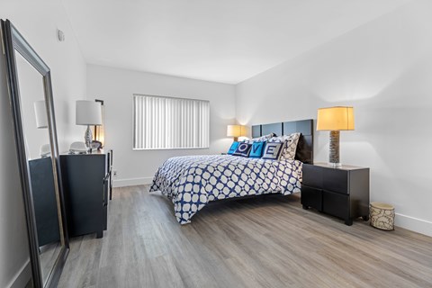 A bedroom with a bed, nightstand, and a lamp.