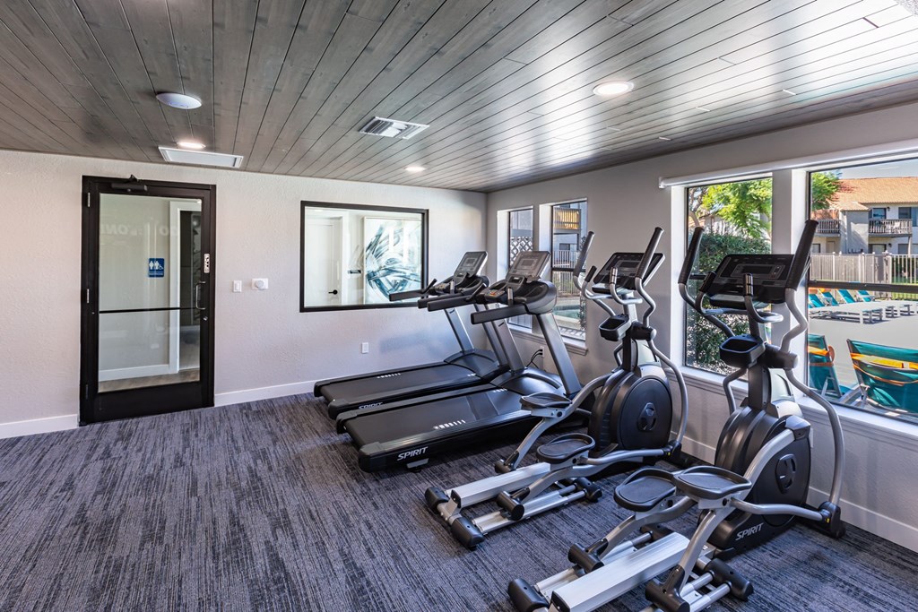 One Bedroom Apartments in Moreno Valley CA - Ardella on Chagall - Fitness Center with Cardio Equipment, Large Windows, and View of the Pool