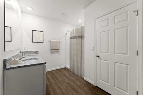 A bathroom with a sink, mirror, and towel rack.