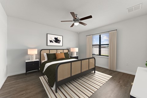 A bedroom with a bed, nightstand, and a ceiling fan.