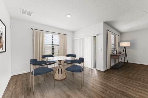 A dining room with a round table and chairs.