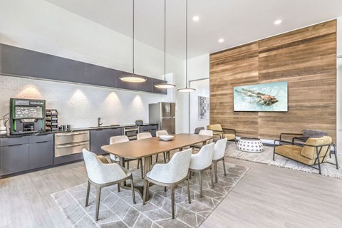 a dining area with a long wooden table and white chairs
