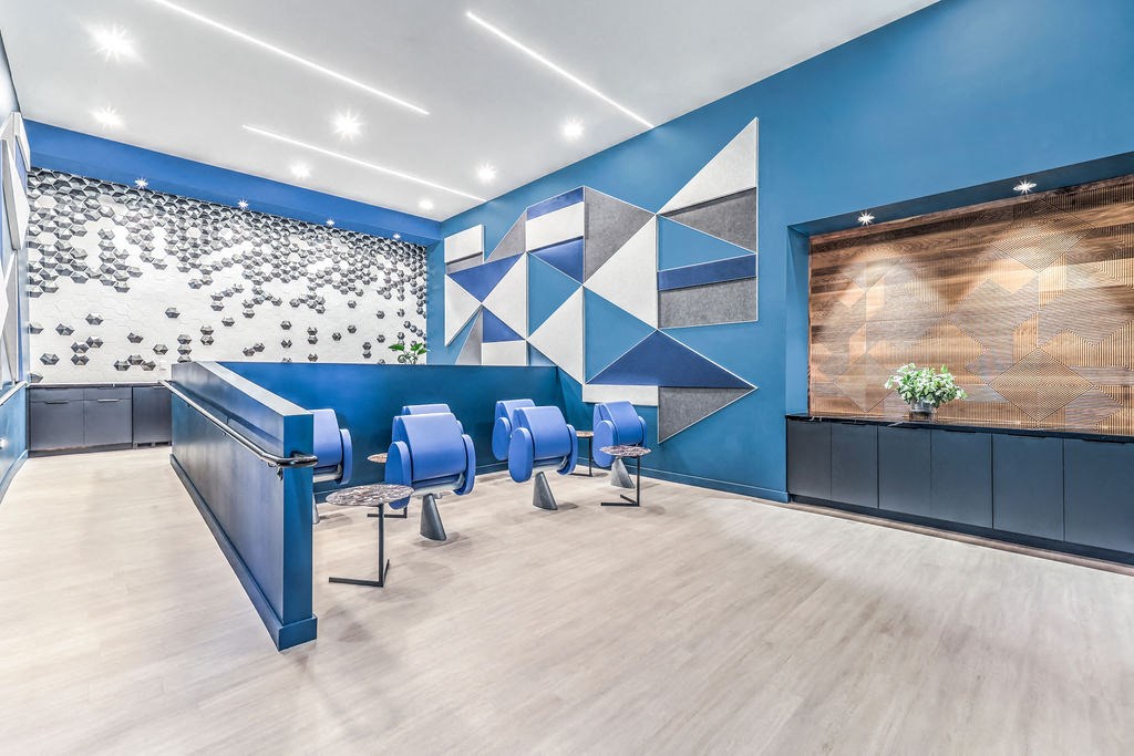 a room with blue chairs and a blue wall with a geometric design