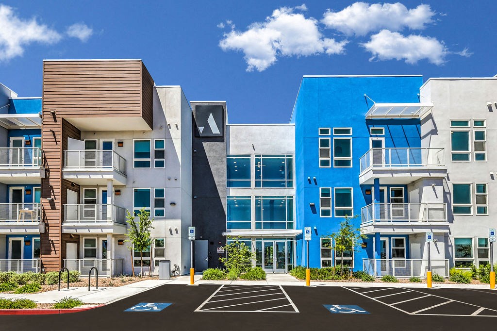a photo of a building with parking spaces in front of it and a blue sky in the