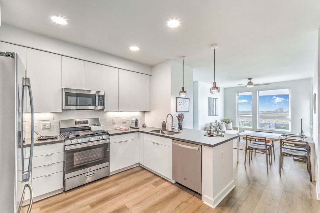 a kitchen with white cabinets and a wooden floor