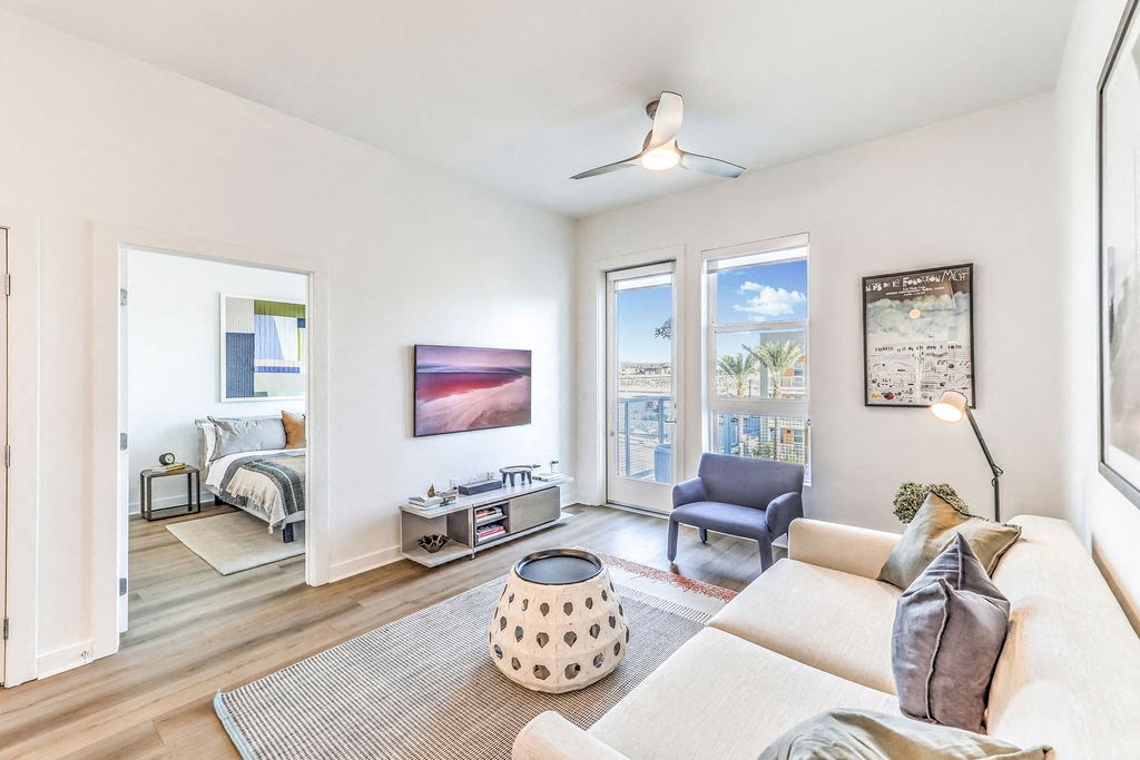a living room with a couch and a chair and a door that leads to a bedroom