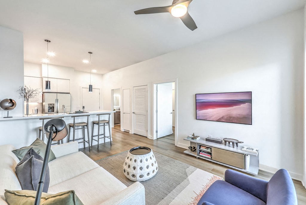 a living room with white walls and hardwood floors