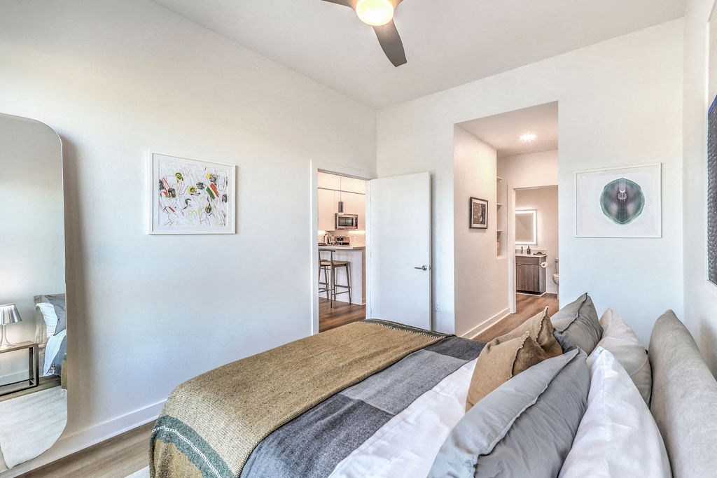 a bedroom with a large bed and a ceiling fan