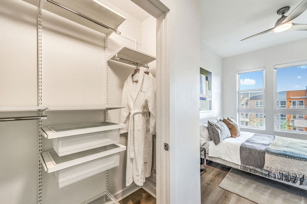 a walk in closet in a 555 waverly unit with a white robe hanging on the