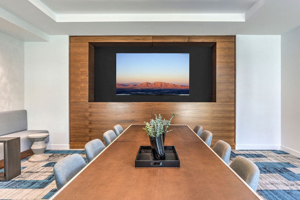 a conference room with a table and chairs and a flat screen tv on the wall