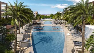 a large pool with palm trees and umbrellas at a resort