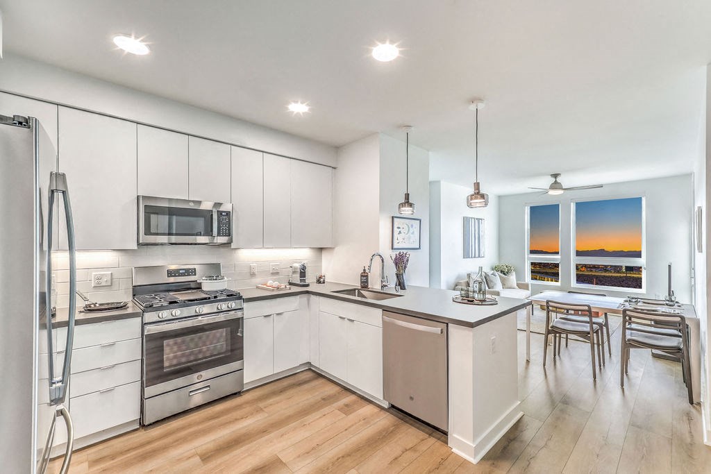 a kitchen with white cabinets and a wooden floor