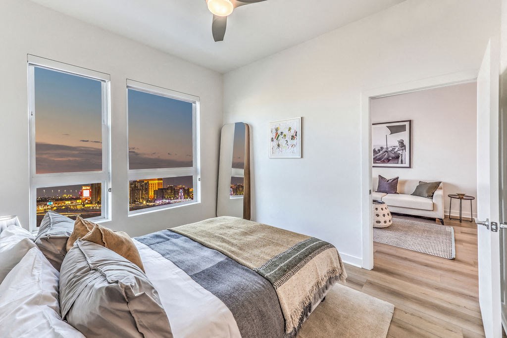 a bedroom with a large bed and three windows