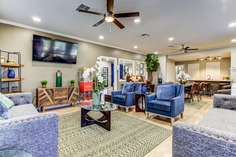 a living room with blue furniture and a ceiling fan
