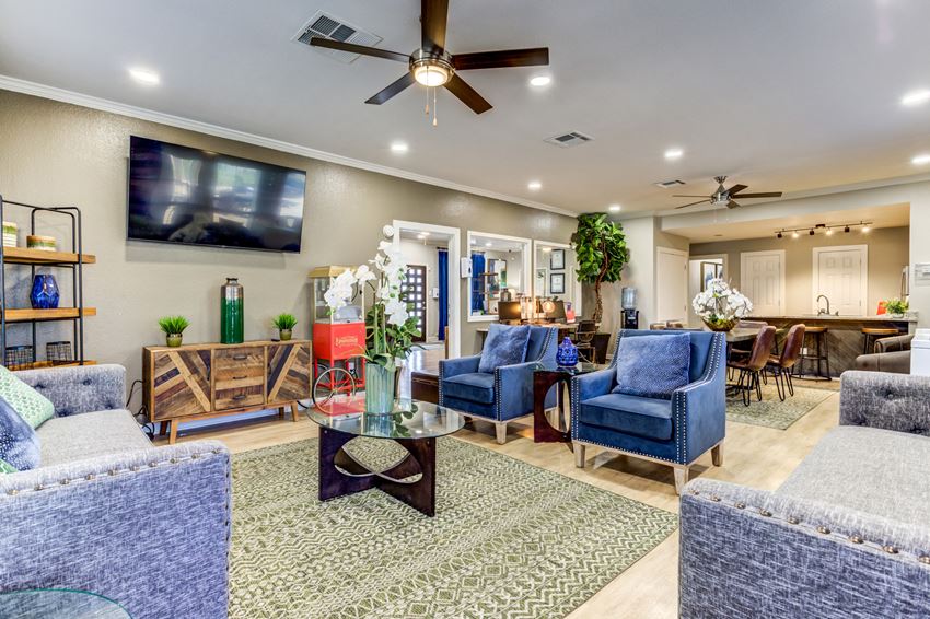 a living room with blue furniture and a ceiling fan