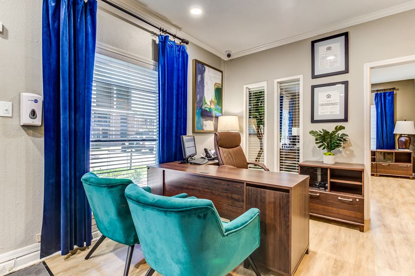 a home office with blue chairs and a wooden desk