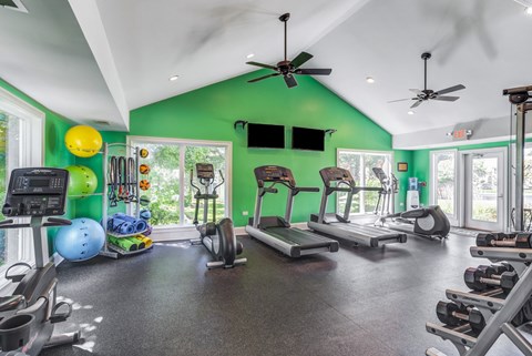 Apartments in Geneva, IL for Rent- Ashford at Geneva-  A gym with a green wall and various exercise equipment.