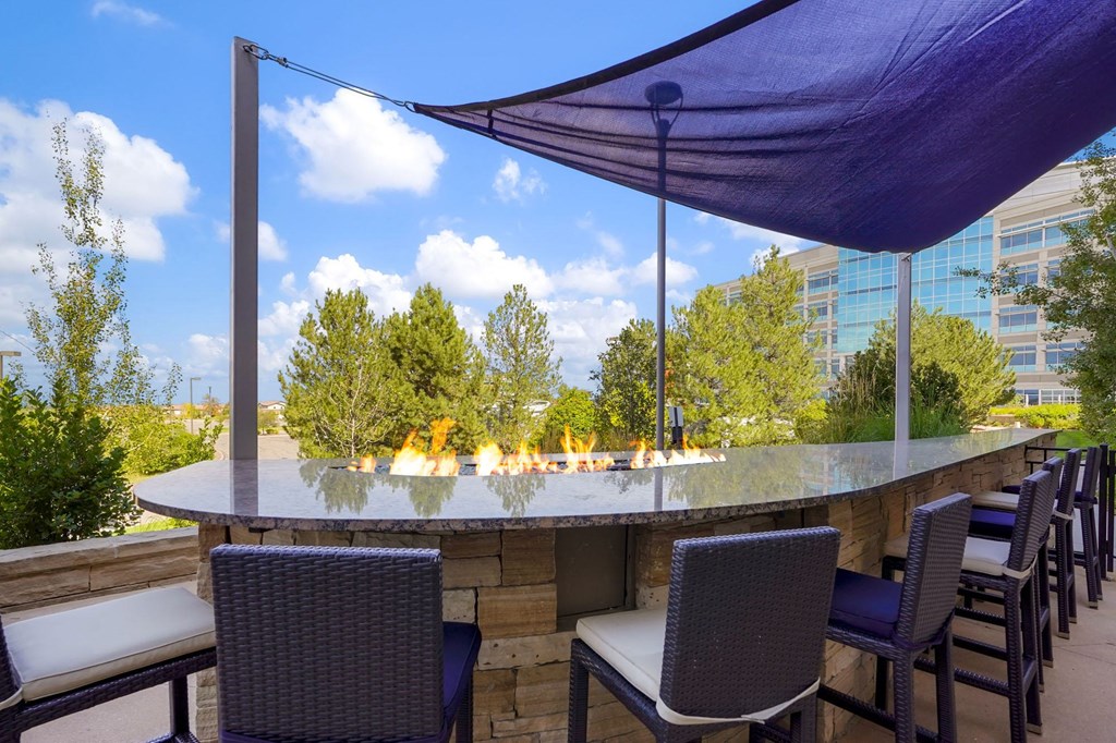 a patio with tables and chairs and a bar