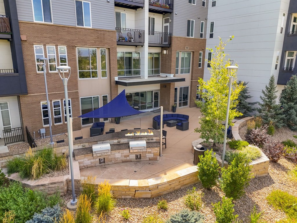 a patio with a fire pit in front of an apartment building