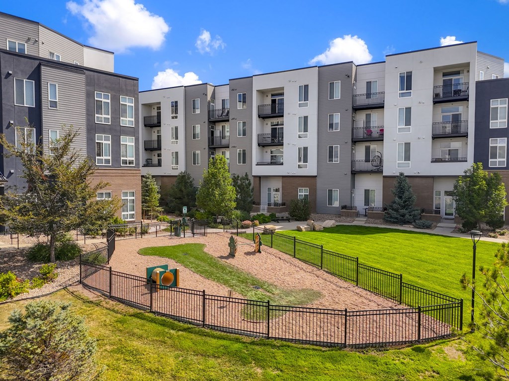 an image of an apartment building with a fenced in dog park