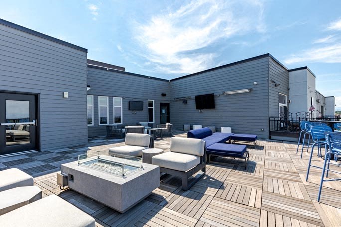 a patio with couches and chairs and a fire pit