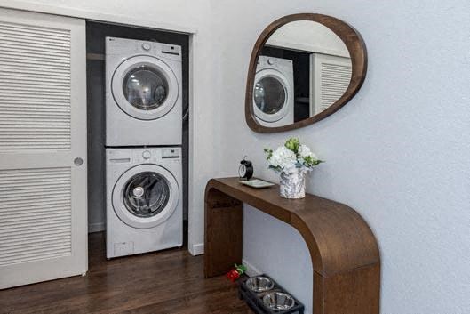 a laundry room with a washing machine and a mirror