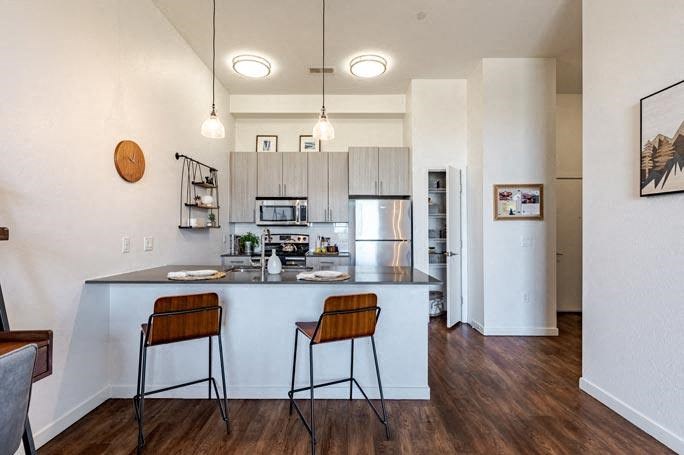 a kitchen with a bar and two stools