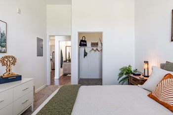a bedroom with a bed and a hallway to a bathroom