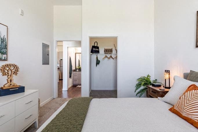 a white bedroom with a bed and a hallway