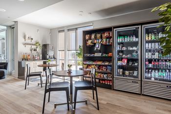 a dining room with a table and chairs in front of a beverage refrigerator