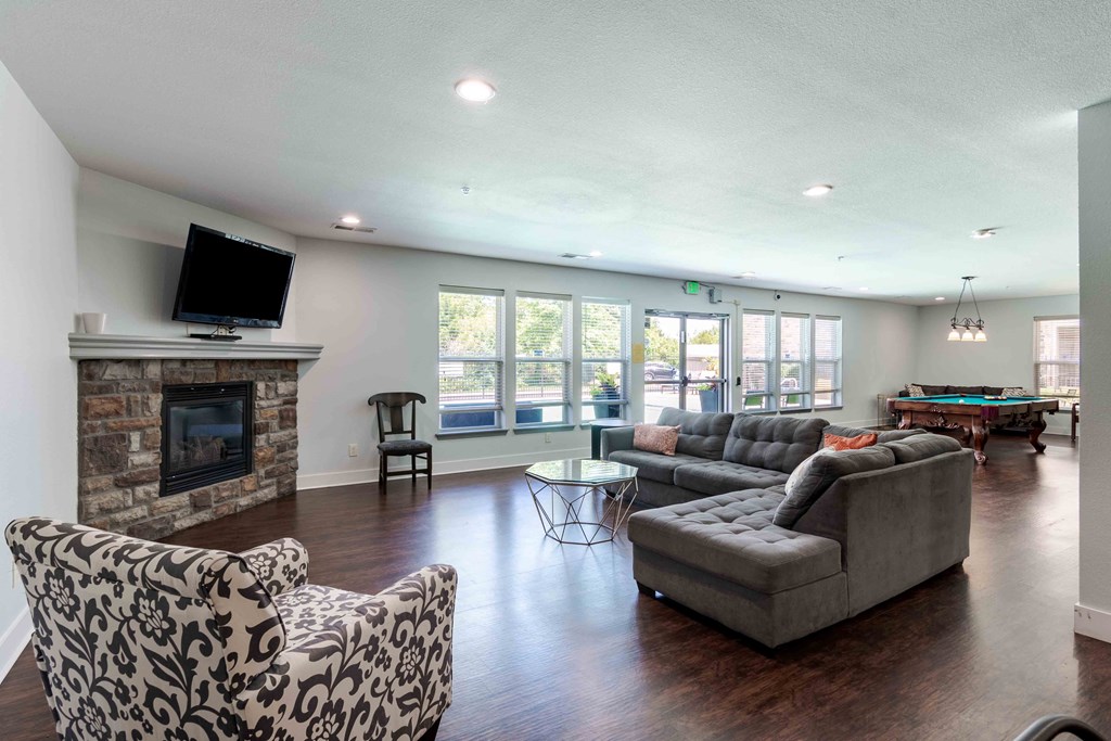 the living room has a large stone fireplace and couches