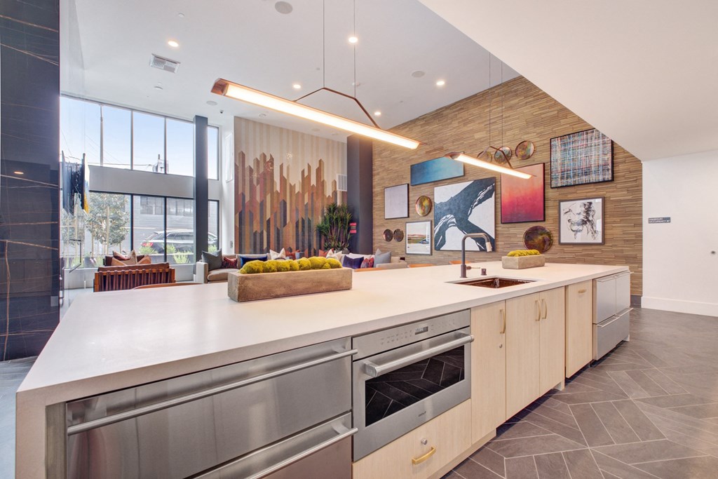 the kitchen has a large island and stainless steel appliances