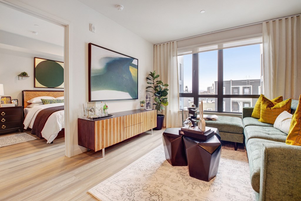 a living room with a bed and a large window