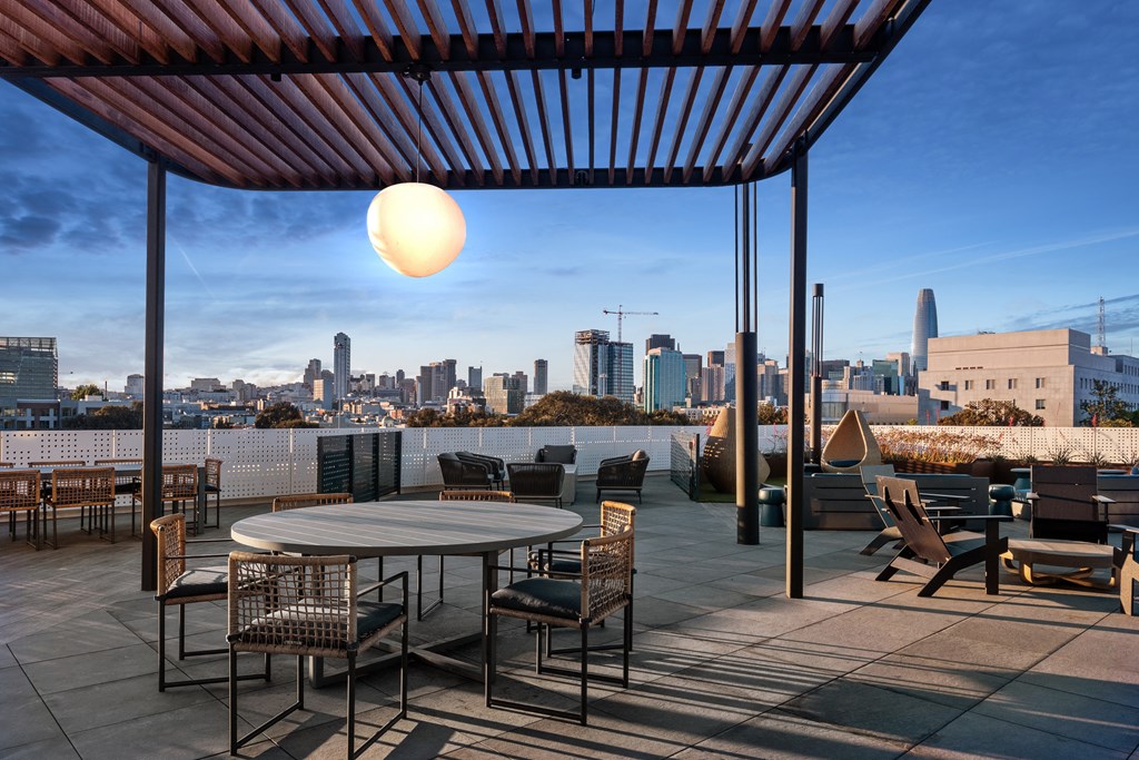 a terrace with tables and chairs and a view of the city