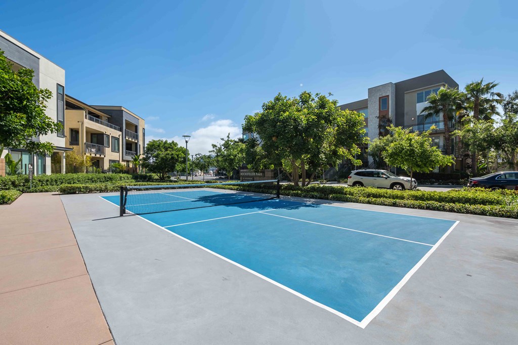 a tennis court with apartments in the background