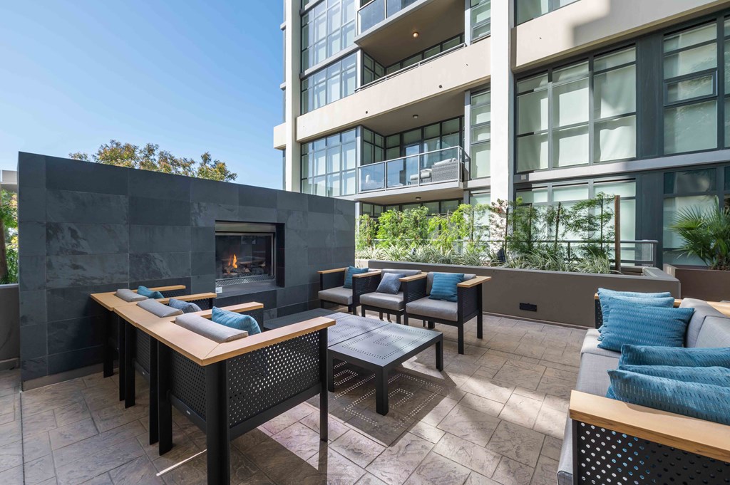 an outdoor patio with tables and chairs and a fireplace