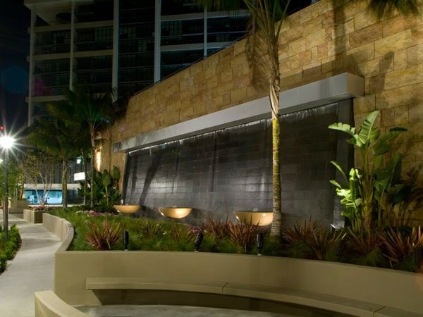 A building with a wall of plants in front of it.